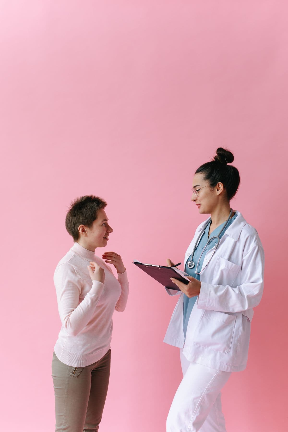A clinician in a white coat talking through next steps with a smiling patient