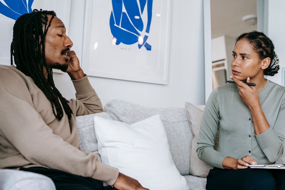 A therapist listening closely to a client during a one-on-one session in a bright office